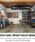Man operating Garage Ceiling Cargo Hoist with metal pulley system, lifting rooftop carrier, in organized garage space.