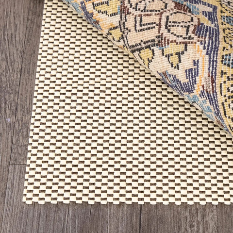 Ivory 3x5 ft Outdoor Non Slip Rug Pad under patterned rug, on wood deck, showcasing weatherproof polyester scrim for durability.