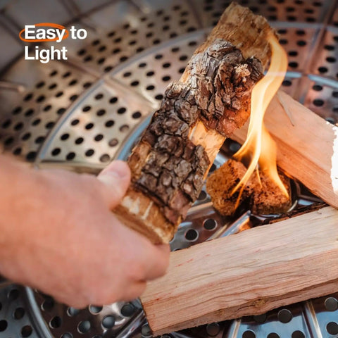 Hand lighting a log in a smokeless 27 inch fire pit for outdoor wood burning, portable stainless steel fireplace with ash pan.