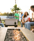 People enjoying drinks near a 125 Qt Gray Party Bar Wheeled Cooler With Ultratherm Insulation Removable Lid That Converts To Open Air Beverage Tub.