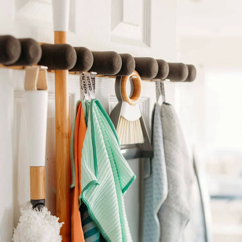 Get A Grip Wall Mounted Mop And Broom Organizer Made Of Lightweight Bamboo With Foam Pegs holding cleaning tools on door
