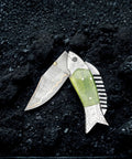 Fish Style Copper Damascus Folding Knife With Ladder Pattern Blade, brass engraved handle on black textured background