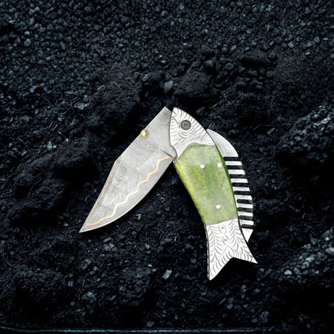 Fish Style Copper Damascus Folding Knife With Ladder Pattern Blade, brass engraved handle on black textured background