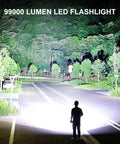 Rechargeable LED Flashlight 99,000 Lumens Ultra Bright Handheld Torch illuminating a deserted road at night
