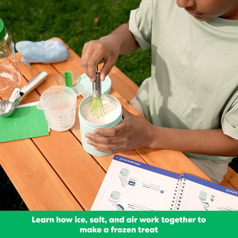 Child using Science Of Cooking Ice Cream Kit For Kids: DIY Hands On Kitchen Chemistry Project at a wooden table.