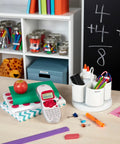 Pink Handheld Label Maker For Home And Office on desk with books and stationery, showing its compact, easy-to-use design.