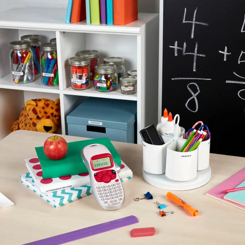 Pink Handheld Label Maker For Home And Office on desk with books and stationery, showing its compact, easy-to-use design.
