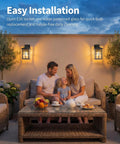 Family enjoying outdoor seating under Black Outdoor Wall Lights Set Waterproof Patio Sconces Crafted From Rust Resistant Die Cast Metal And Tempered Wave Glass Ideal For Backyards And Entryways Sleek Modern Build That Braces Against Snow And Rain Hella Tough Construction Set Of Two.