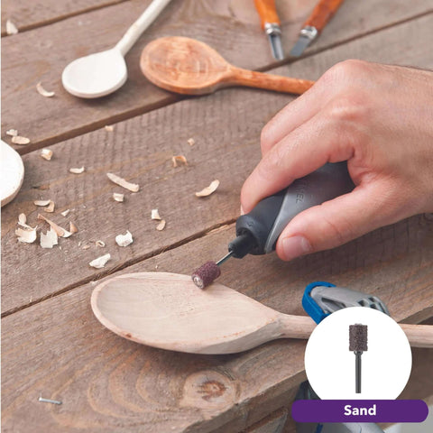 Side view of Dremel Stylo+ craft rotary tool with sanding bit shaping a wooden spoon