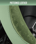 Close-up of green patterned PU leather steering wheel cover showcasing anti-slip grip, designed for modern cars.