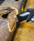 User using Heavy Duty Industry Standard 19 Needle Scaler Kit With Pistol Grip, 3000 BPM, 5.5 CFM at 90 PSI on rusty surface