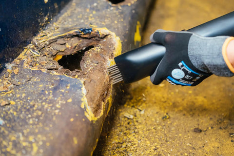 User using Heavy Duty Industry Standard 19 Needle Scaler Kit With Pistol Grip, 3000 BPM, 5.5 CFM at 90 PSI on rusty surface