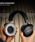 Hands holding DT 770 Pro X Wired Studio Headphones 48 Ohm Closed Back, highlighting soft ear pads and flexible headband.