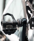 Assioma Uno Single Sensing Left Pedal Power Meter with Bluetooth and ANT Plus on road bike, close-up view.