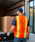 Worker loading box wearing High Visibility Reflective Jobsite Ready Safety Vest With Multi Function Pockets Zipper And Velcro Closure