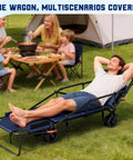 Man relaxing on Heavy Duty Folding Wagon 2 In 1 Cart And Beach Chair with family picnic, all terrain wheels visible