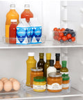 Two Pack Nine Inch Clear Acrylic Lazy Susan Turntable Spinner With Non Slip Base For Kitchen Pantry Cabinet Fridge And Makeup Tray That Is A Straight Up Game Changer For Decluttering Your Home Hella Sturdy holding various drinks and food items in a refrigerator.