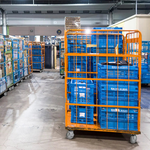 Image of warehouse with blue plastic bins on Heavy Hitter Grade Rubber Caster Wheels 5 Inch Industrial Casters Set Of 4.