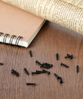 500 Pieces Tiny Screws Micro Repair Kit M1.2 M1.4 M2.0 Assortment For Glasses Watches Laptops And Electronics With Handy Screwdriver Replacement Small Screws In Black scattered on a desk