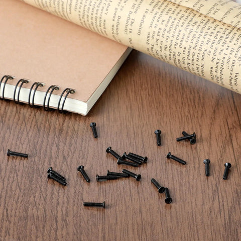 500 Pieces Tiny Screws Micro Repair Kit M1.2 M1.4 M2.0 Assortment For Glasses Watches Laptops And Electronics With Handy Screwdriver Replacement Small Screws In Black scattered on a desk