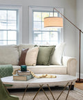 Tall Arc Floor Lamp With Sturdy Base In Rubbed Bronze LED Reading And Living Room Light Adjustable Arm For Dope Mid Century Modern Vibe Bedroom And Office Decor beside a sofa in a cozy living room setting.