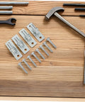 Heavy Duty Wall Mount Gate Hinges 4 Pack Galvanized Iron Frame Weather Proof Design showing hinges and screws on a wooden surface.