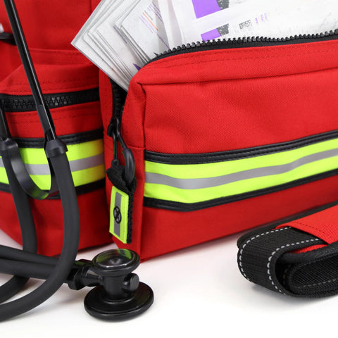 Front view of red mid-sized EMT bag with neon yellow reflective stripes; stethoscope visible in foreground.