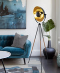 Lit Modern Tripod Floor Lamp in black finish with gold foil shade and leather legs, 58-inch tall, mid-century style in living room