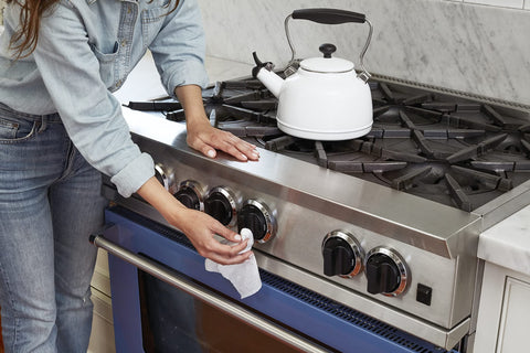 Person cleaning stainless steel stove with All Purpose Cleaning Wipes French Lavender Scent for Multi Surface Use Compostable Wet Wipes 70 Count Pack of 1 Cruelty Free Awesome for Counters Tile Stone Wood Glass and More.