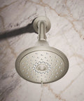 Forté Three-Function Showerhead With Full Coverage, Pulsating Massage And Silk Spray, installed against a marble wall