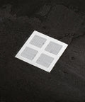 Nukinp Disposable Hair Drain Stickers, 60 Pack 4x4 Fiberglass Disposable Drain Covers on a dark surface.