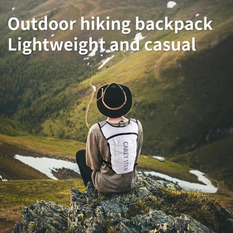 Person wearing Ultra Lightweight Hydration Backpack For Women With 1.5L Water Bag No Bounce Running Vest in white, sitting on a hill.