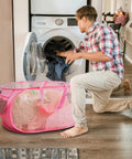 Person using Foldable Mesh Laundry Basket Pop Up Hamper With Reinforced Handles, Collapsible Dirty Clothes Carrier, Pink