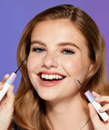 Smiling woman holding All Day Lash Bond And Seal With Biotin And Vitamin E For Falscara Lashes, showing applicator wands.