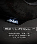 Tire pressing on a waterproof solar powered LED deck light made of aluminum alloy, part of 6 pack for walkways and driveways.