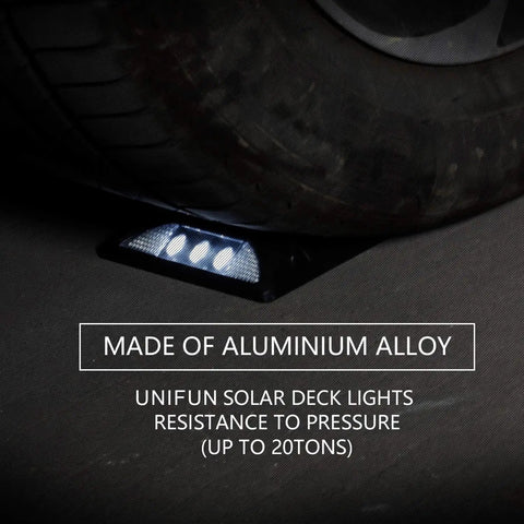 Tire pressing on a waterproof solar powered LED deck light made of aluminum alloy, part of 6 pack for walkways and driveways.
