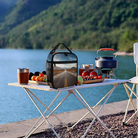 Reusable Insulated Lunch Box With Side Pocket And Detachable Handle for picnics by a lake with fruit and camping gear on table