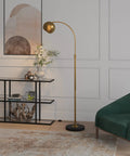Arc Floor Lamp In Brass And Blackened Bronze For Living Room Bedroom Office And Dining Areas With Adjustable Head Two Tone Modern Pharmacy Style Eye Catching Minimalist Lighting Upgrade standing beside console table in a modern living room.