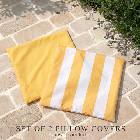 Outdoor Pillow Covers Set Of 2 18x18 Waterproof Throw Pillow Covers for Porch and Patio, yellow and striped design on stone surface.
