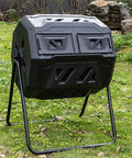 Dual Chamber Outdoor Tumbling Compost Bin With Lid in a garden, 160L capacity, black, made of food grade plastic.