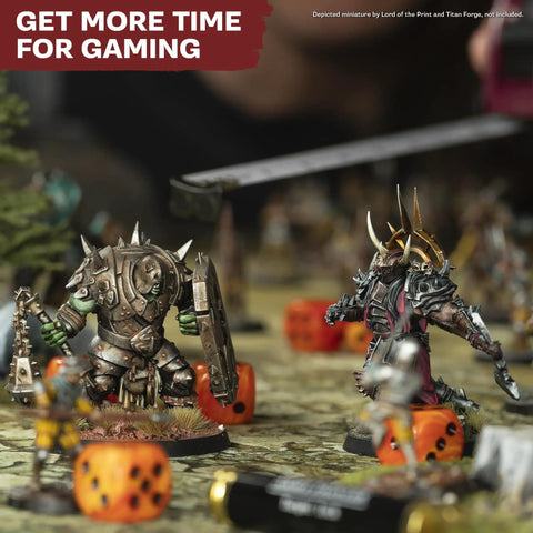 Warhammer miniatures on a tabletop with dice, showcasing the One Box Fits All Hobby Tool Kit With Glue And Six Essential Tools