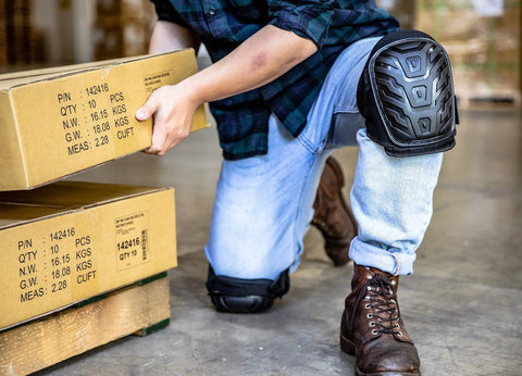 Person wearing All Day Comfort Heavy Duty Gel Knee Pads With Thick Foam Padding for construction work, kneeling with boxes
