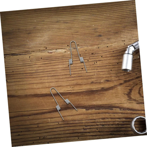 Upgrade Your Kitchen With 4 Pack Stainless Steel Dual Torsion Spring Kit For Garbage Can Press Top Lid, Smooth Silent Lid Operation, Easy DIY Fix For Trash Bin Repair And Maintenance. Four stainless steel torsion springs on wood surface