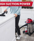 Person using Heavy-Duty 8-Gallon Stainless Steel Wet/Dry Vacuum With Boss-Level Suction, 83-Inch Lift in a kitchen setting.