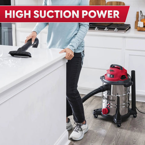 Person using Heavy-Duty 8-Gallon Stainless Steel Wet/Dry Vacuum With Boss-Level Suction, 83-Inch Lift in a kitchen setting.