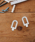 Two pro-grade aluminum pull rings from the Three Piece Aluminum Dent Puller Ring Kit For Auto Body And Sheet Metal Repair on wooden surface.