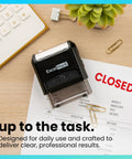 Heavy Duty Self Inking Rubber Office Stamp Printing Crisp Closed Messages In Bold Red Ink With A Quick Swap Replaceable Pad on desk.