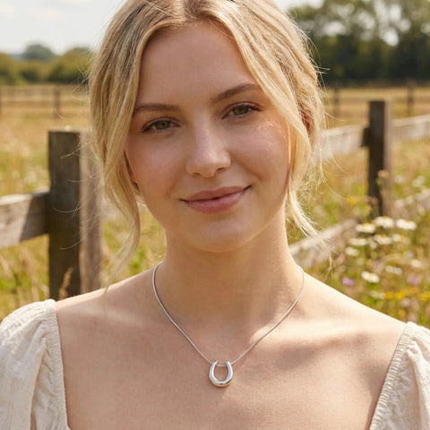 Woman wearing Lucky Horseshoe Necklace for Women with U Shape Pendant in silver tone stainless steel against outdoor backdrop
