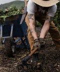 Gardener using Foldable Spading Fork for digging and aerating durable steel garden tool with easy twist lock.
