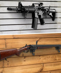 Gun Rack Wall Mount Kit with 12 Vinyl Coated Steel Hooks for Slatwall, displaying rifle and shotgun on wooden panels.